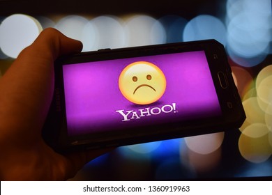 Milan, Itali. 4 April 2019 - Close up of yahoo messanger with sad emoji image on Smartphone Display with bokeh background. 