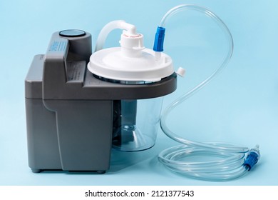 Milan, Italy - 01.04.2020: Medical Suction Machine On Blue Background. Portable Aspirator Used To Remove Mucus, Blood, Bodily Fluids From Patient. Medical Equipment Using In Ambulances, Nursing Homes