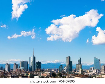 Milan, Italy - 08/10/2016: Panoramic View Of Milan City Skyline, Background Is A Clear Blue Sky; Mountains Are Visible Far Far Away.