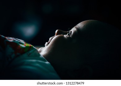 Milan, Italy -  20 July 2018:  Smiling Newborn Baby With Happy Open Eyes In Dark Room With Soft Natural Light