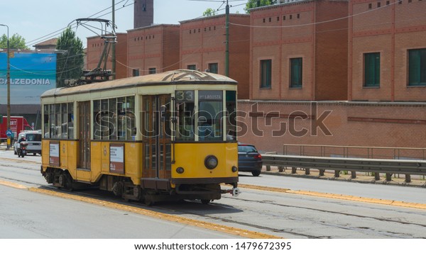 Milan, Italy -\
21.6.2019: Historical old yellow tram in city center of town Milano\
in Lombardia region. Original public transport tramway wide screen\
on street. Aspect ratio\
16:9.