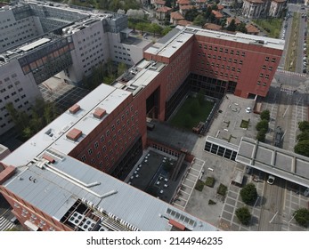 Milan, Italy - April 2022 - Aerial view of Bicocca University campus in Milan, near station of Greco Pirelli. Drone and birds eye of one of the best university in Milano. Modern red buildings.