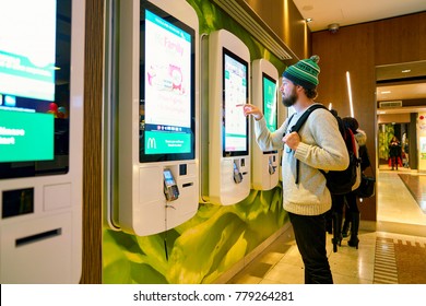 MILAN, ITALY - CIRCA NOVEMBER, 2017: customer at a McDonald's store place orders and pay through self ordering kiosk.