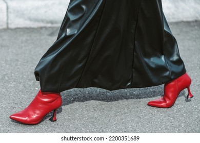 MILAN, ITALY - FEBRUARY 24: Street Style Outfit - Woman Wearing Black Leather Skirt And Red Shoes.