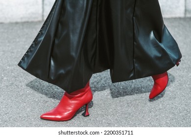 MILAN, ITALY - FEBRUARY 24: Street Style Outfit - Woman Wearing Black Leather Skirt And Red Shoes.