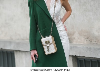 Milan, Italy - February, 24: Street Style, Woman Wearing A Dark Green Coat, A White Handbag, White Pants, Snake Print Pattern Ankle Boots.