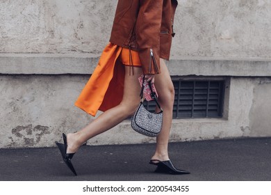 Milan, Italy - February, 24: Street Style, Woman Wearing A Black Turtleneck Top, Orange Mini Skirt With Train, Black Heels And Prada Bag.