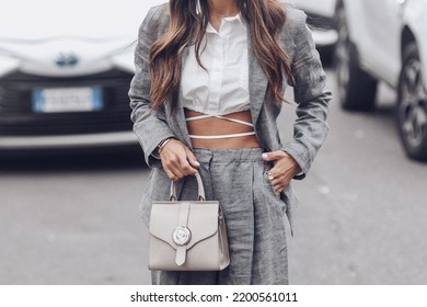 Milan, Italy - February, 24: Street Style, Woman Wearing White Cropped Shirt, A Gray Blazer Jacket, Gray Matching Suit Pants, A Beige Leather Handbag And Yellow Green Open Toe-cap Pumps Sandals.