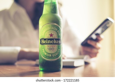 MILAN, ITALY - JANUARY 16, 2014: Woman Drinking Heineken Beer Glass Bottle 33 Cl. Heineken International Is A Dutch Brewing Company, Founded In 1864 In Amsterdam, Famous All Over The World.