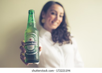 MILAN, ITALY - JANUARY 16, 2014: Woman Drinking Heineken Beer Glass Bottle 33 Cl. Heineken International Is A Dutch Brewing Company, Founded In 1864 In Amsterdam, Famous All Over The World.