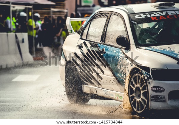 Milan, Italy, June 02, 2018: closeup on\
wheels of a Mitsubishi Lancer Evolution in action on wet asphalt\
during a rally race at the Iper Drive in\
Milan.