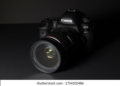 Milan, Italy - June 11, 2020: close up on a Canon EOS 5D Mark IV with EF24-70mm f/2.8 L USM lens, resting on a black background.