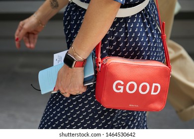 MILAN, ITALY - JUNE 15, 2019: Woman with red Paul Smith leather bag before Emporio Armani fashion show, Milan Fashion Week street style 