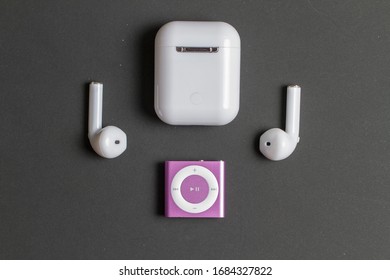 Milan, Italy - March 25, 2020: close up on Apple iPod Shuffle and AirPods resting on a black backgruond.
