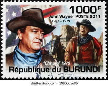 Milan, Italy - May 08, 2021: John Wayne and american flag on postage stamp