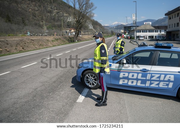 MILAN, ITALY - MAY 8, 2020. Italian Police\
controls on the road. Officers with masks and gloves monitor\
passing motorists. Street control for the Covid-19 with a\
policewoman. Police\
checkpoint.