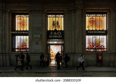 Milan, Italy - November 17 2021: FAO Schwarz Toy Store Facade, With Sign. Illuminated Night View Exterior Of American Brand Shop Selling Toys At Via Orefici, With Crowd Outside.