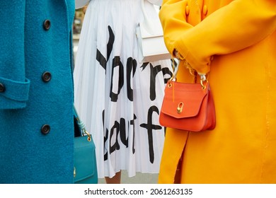 MILAN, ITALY - SEPTEMBER 18, 2019: Women with blue, orange coat and white dress, street style 