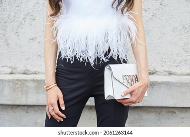 MILAN, ITALY - SEPTEMBER 18, 2019: Woman with white leather Prada bag and shirt with feathers, street style 