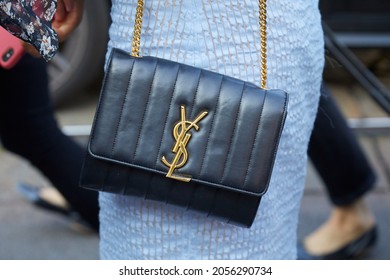 MILAN, ITALY - SEPTEMBER 19, 2019: Woman With Black Leather Yves Saint Laurent Bag With Golden Logo And Blue Dress, ​street Style