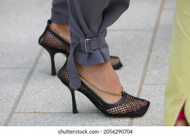 MILAN, ITALY - SEPTEMBER 20, 2019: Woman with black high heel net shoes and gray trousers, street style 