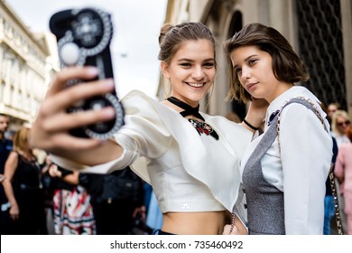 MILAN, ITALY - SEPTEMBER 21, 2017: Two Woman Using Smart Phone Attending Fashion Show During Milan Fashion Week Women Spring/Summer 2017/2018