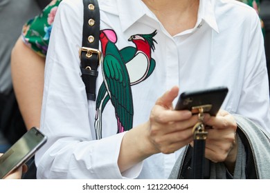 MILAN, ITALY - SEPTEMBER 21, 2018: Woman With White Shirt With Birds Design Looking At Smartphone Before Sportmax Fashion Show, Milan Fashion Week Street Style