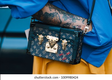 Milan, Italy - September 22, 2017: Tatoo girl with a stylish outfit wearing a Louis Vouitton luxuty handbag.