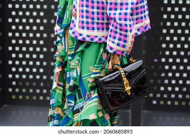 MILAN, ITALY - SEPTEMBER 22, 2019: Woman With Black Patent Leather Bag With Golden Belt And Green Skirt, Street Style 