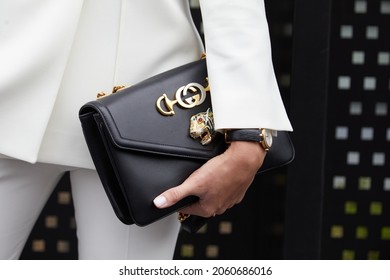 MILAN, ITALY - SEPTEMBER 22, 2019: Woman with black leather Gucci bag with golden tiger head, street style 