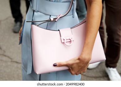 MILAN, ITALY - SEPTEMBER 25, 2021: Woman with pale blue leather sleeveless dress and pink Ferragamo bag, street style