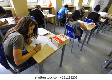 MILAN, ITALY-JUNE 20, 2012: College Students Seat On School Desk In The Exam Room, For The Secondary School's Final Exams, At The Artemisia Gentileschi School In Milan.