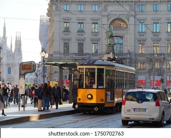 Milan, Italy-October, 2019: Busy Urban Scene At Piazza Cordusio Square. People Are Traveling. A Tram Parks At Tram Stop. Duomo And Generali Building Can Be Seen As The Background.