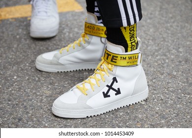 MILAN - JANUARY 15: Man with Off White sneakers with yellow belt before Represent fashion show, Milan Fashion Week street style on January 15, 2018 in Milan.