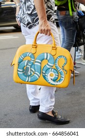 MILAN - JUNE 17: Man With With Gucci Yellow Bag With Blue Snake And White Trousers Before Les Hommes Fashion Show, Milan Fashion Week Street Style On June 17, 2017 In Milan.