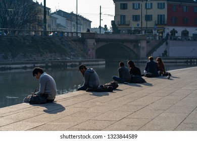 Milan, Lombardy / Italy - February 22nd 2019: People and tourists in famous Navigli District area. Ancient harbour where Naviglio Pavese and Naviglio Grande canals meet.