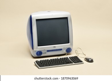 Milan, Lombardy, Italy - June 16, 2019: Apple iMac G3 computer from 1998 in original Indigo blue color with mouse and keyboard isolated on beige background