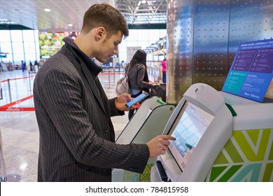MILAN MALPENSA, ITALY - CIRCA NOVEMBER, 2017: a passenger use Alitalia self service check-in kiosks at Milan-Malpensa airport, Terminal 1. 