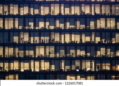 MILAN - NOV 8: Rows Of Windows With People Working In The Interior Of An Office Building At Night In Milan, Italy On November 8, 2018. Concept For Employment, Business, Corporate, Working, Modern Life