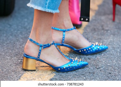 MILAN - SEPTEMBER 21: Woman with blue metallic shoes with studs and golden heel before Prada fashion show, Milan Fashion Week street style on September 21, 2017 in Milan.