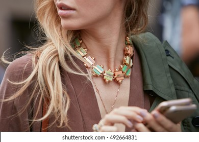 MILAN - SEPTEMBER 22: Woman with colorful necklace and two smartphone before Max Mara fashion show, Milan Fashion Week street style on September 22, 2016 in Milan.