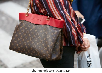 MILAN - SEPTEMBER 23: Woman with Louis Vuitton bag with red border and striped shirt before Antonio Marras fashion show, Milan Fashion Week street style on September 23, 2017 in Milan.