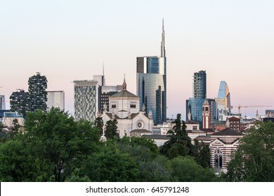 Milan skyline at sunset with modern skyscrapers in Porta Nuova business  district in Italy. Panoramic view of Milano city. The mountain range of the  Lombardy Alps in the background. Stock Photo