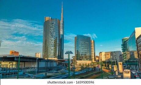 Milan skyline with modern skyscrapers in Porta Nuova business district timelapse in Milan, Italy, at sunset with orange light. Traffic on the road. Light in windows. Top view from bridge