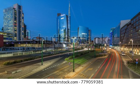 Milan skyline with modern skyscrapers in Porta Nuova business district day to night transition timelapse in Milan, Italy, after sunset. Traffic on the road. Light in windows. Top view from bridge