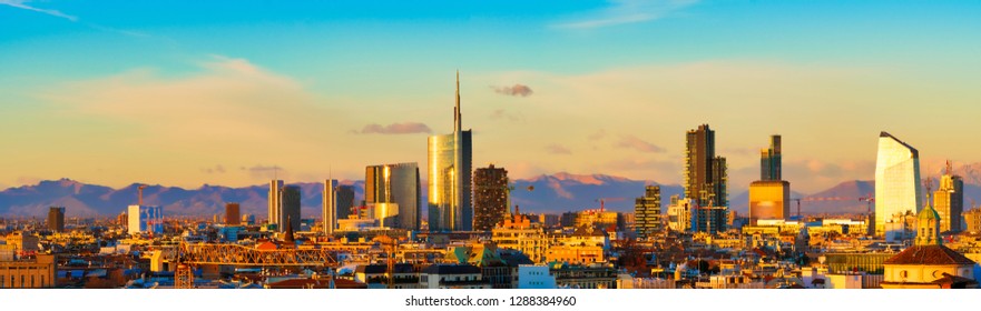 Milan skyline at sunset. Large panoramic view of Milano city, Italy. The mountain range of the Lombardy Alps in the background. Italian landscape.