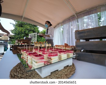 MILANO, ITALY - Jul 07, 2021: A Waitress Wearing Gloves And A Covid Mask, Serving Food In A Buffet At A Private Event