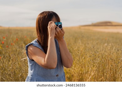 mild adult woman using old camera to take photo. hobbies. Day international of photography - Powered by Shutterstock
