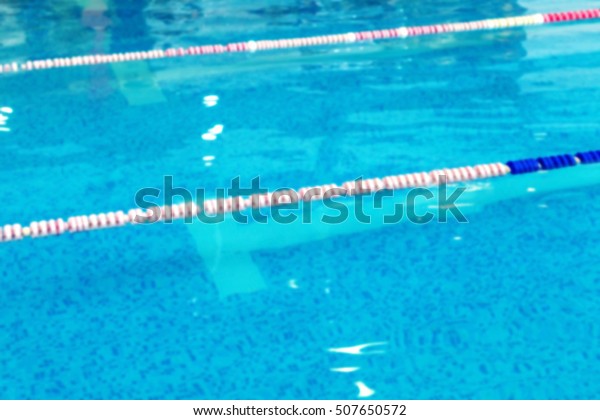 Mild blurred background Sports Swimming Pool. Bath\
Interior sports pool, divided swimming lanes for swimmers, tables\
to start during the competition. Mild background without focus as\
blank for design