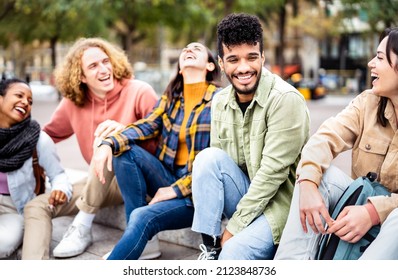 Milenial friends sitting together at city center on life style concept - Happy guys and girls having fun talking around Barcelona street - University students on travel vacation  - Bright vivid filter - Shutterstock ID 2123848736